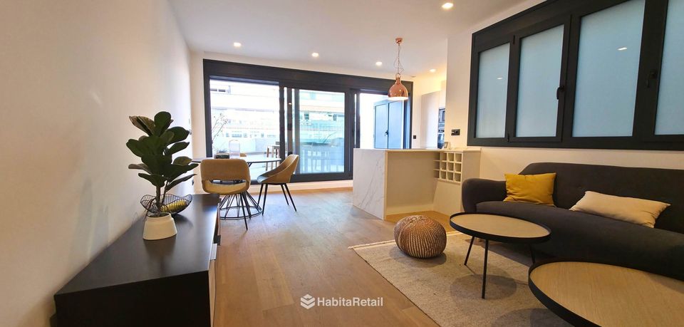 Salón con la cocina abierta y salida a la terraza principal